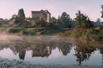 Historic Castle by the Riverbank with Mirrored Reflection