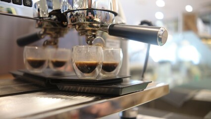 person barista using modern grinder machine to prepare coffee grounds in cafe features digital display and  polished metal finish.  