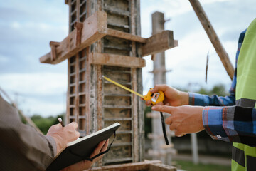 A construction worker inspects a concrete pillar using a level, ensuring precision and quality...