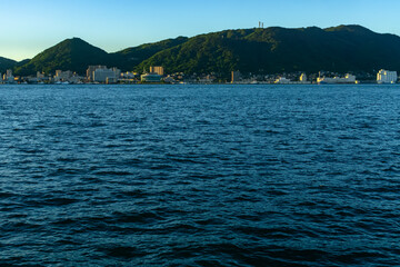 朝の関門海峡と企救半島の街並みと山並みの遠望20240705-1