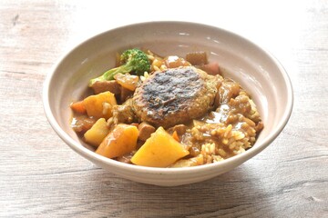 hamburg crispy fried chop pork with boiled vegetable topping plain rice dressing potato and carrot in Japanese curry on bowl