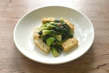stir fried Chinese cabbage with slice tofu and chop pork in soy sauce on plate