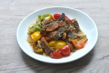 deep fried slice mango fish with bell pepper and onion in black pepper sauce on plate 