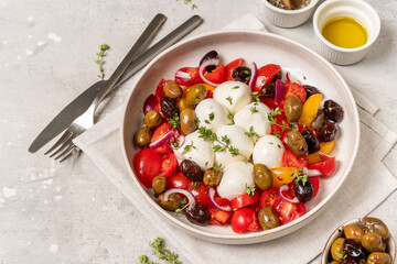 Сaprese salad with balls of Italian mozzarella cheese with ripe seasonal tomatoes, olives, fresh organic aromatic herbs and olive oil of high quality, balanced diet, Mediterranean diet