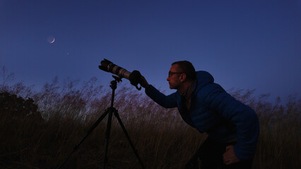 Amateur astronomer using camera and lens for photographing stars, Moon, planets and other celestial...
