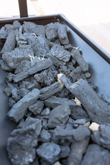 Charcoal pieces arranged in a metal tray