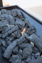 Charcoal briquettes igniting for outdoor barbecue