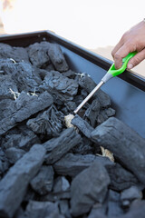 Hand lighting charcoal briquettes for grilling