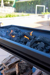 Outdoor barbecue grill with burning charcoal logs