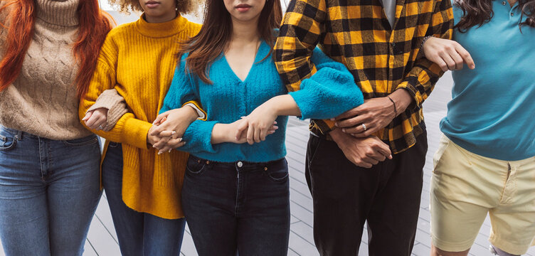 Multiracial activists standing with arms in arms
