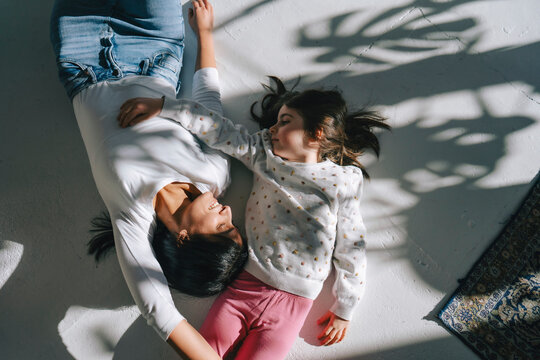 Mother and daughter lying on the floor enjoying quality time together