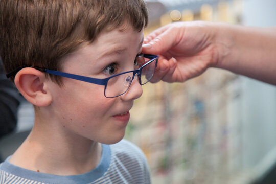 Young boy trying on different frames for new glasses
