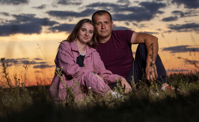 Couple enjoying a serene sunset in a meadow: embracing the golden hour