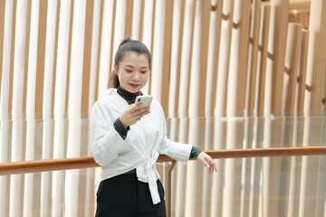 Beautiful woman leaning on railing using mobile phone