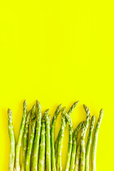 Asparagus steams frame on yellow background top-down copy space