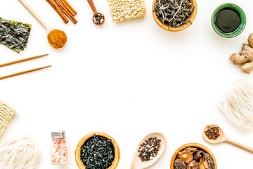 Chinese and Japanese food cooking with ginger, spices and noodles frame on white background top view mock up