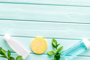 skin care cosmetics with facial tonic, mycelial water and sponge on mint greem background top view mockup