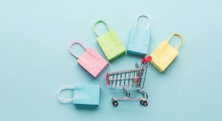 Small shopping cart surrounded by colorful gift bags on a blue background