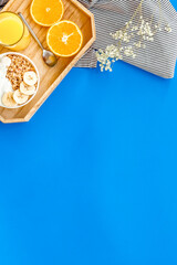 Bright breakfast with granola and orange juice on blue background top view mockup