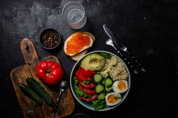 Couscous with boiled egg and vegetables in a plate on the table