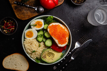 Couscous with boiled egg and vegetables in a plate on the table