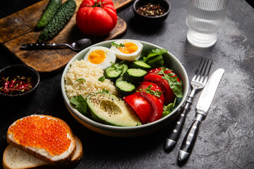 Couscous with boiled egg and vegetables in a plate on the table