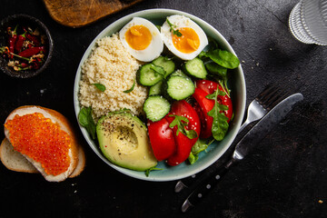 Couscous with boiled egg and vegetables in a plate on the table