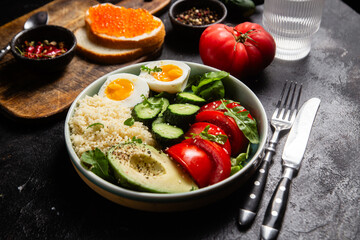 Couscous with boiled egg and vegetables in a plate on the table