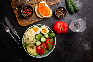 Couscous with boiled egg and vegetables in a plate on the table