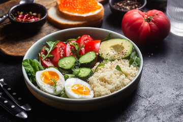 Couscous with boiled egg and vegetables in a plate on the table