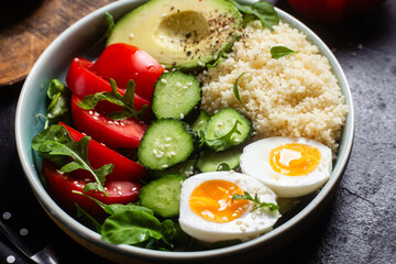 Couscous with boiled egg and vegetables in a plate on the table