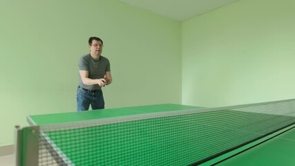 Man playing competitive table tennis with red paddle in professional indoor court - Powered by Adobe
