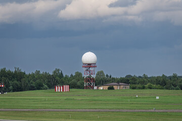 Meteorological Radar Tower in a Green Landscape with Cloudy Sky in the Airport