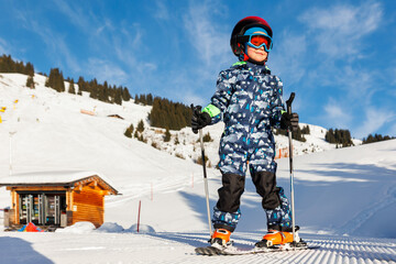 Scenic portrait view kid beginner skier close-up downhill start line rows freshly prepared groomed...