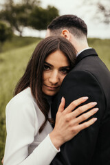 Brunette Bride In Focus Tenderly Hugs Groom, Romantic Couple