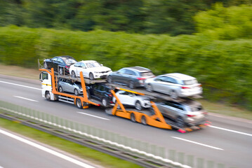 Fast Moving Car Transporter Truck Carrying Multiple Vehicles in Blurred Motion