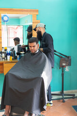 Hairdresser cutting hair of customer in beauty salon