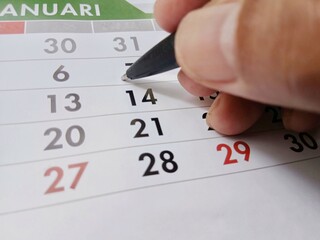 A person marks the date with a pen. Illustration.