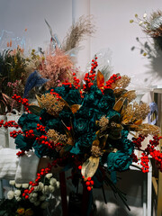 Beautiful floral arrangement with teal roses and golden accents in a shop setting