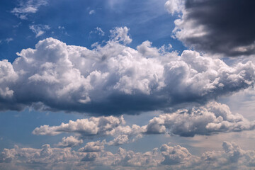 A large white cloud among other cumulus clouds to the horizon with white clouds, cloudy weather and...