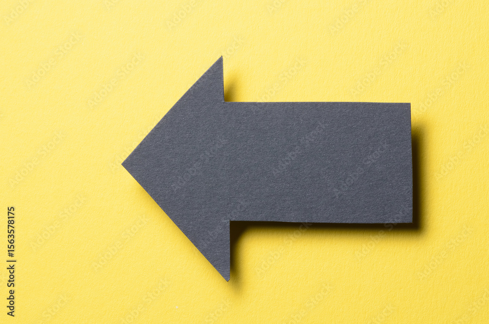 Fototapete black cut out blank paper cardboard arrow direction sign with copy space for text on yellow backgrou