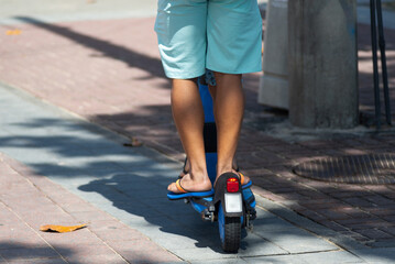 A person is seen riding an electric scooter on a street in the Barra neighborhood during a sunny day in the city of Salvador, Brazil.