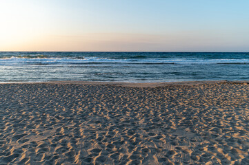 Sunset beach view in Crete, Greece with gentle waves and sandy shoreline