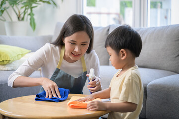 Asian mother and son doing house cleaning together at home. Family bonding through household...