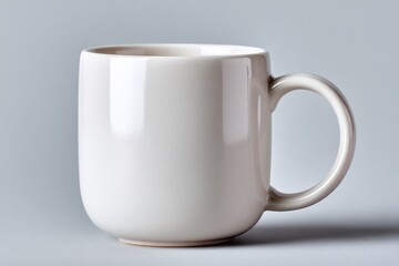 Obraz premium Plain White Ceramic Coffee Mug with Smooth Curved Handle Isolated on Light Gray Background for Drinking and Beverage Storage
