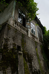 The old, dirty shabby facade of the building in the park