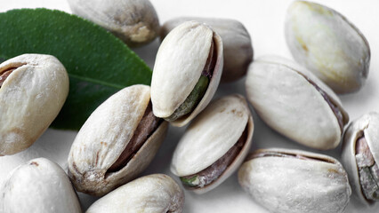 Close-up of Pistachios and Green Leaf on a White Background, Healthy Eating Concept