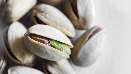 Close-up of Cracked Pistachios Revealing Texture and Color on a Light Background