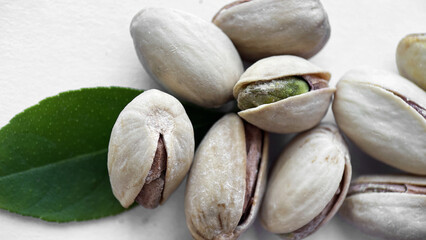 Close-up of Pistachios and Green Leaf on a White Background, Healthy Eating Concept