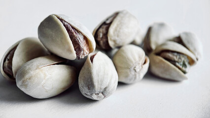 Close-up of Cracked Pistachios Revealing Texture and Color on a Light Background
